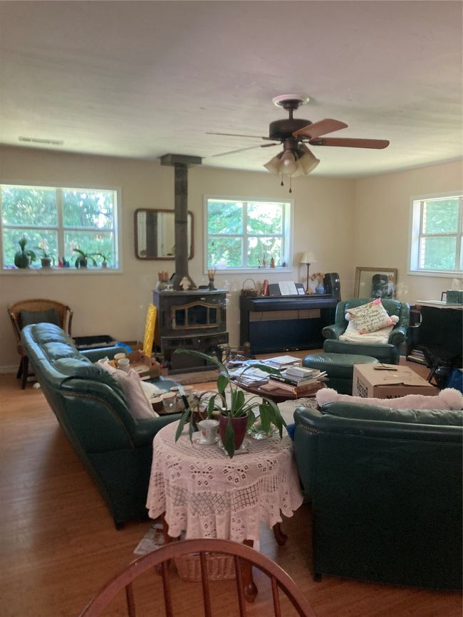 Living room featuring a wood stove, plenty of natural light, and wood finished floors very large open space | Image 20