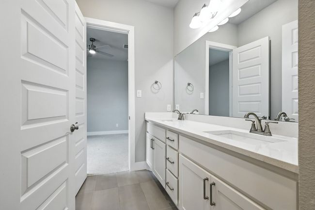 Full bathroom featuring double vanity, ceiling fan, and tile patterned floors | Image 23