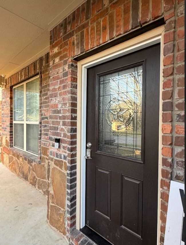 View of exterior entry with brick siding, with view of patio. | Image 8