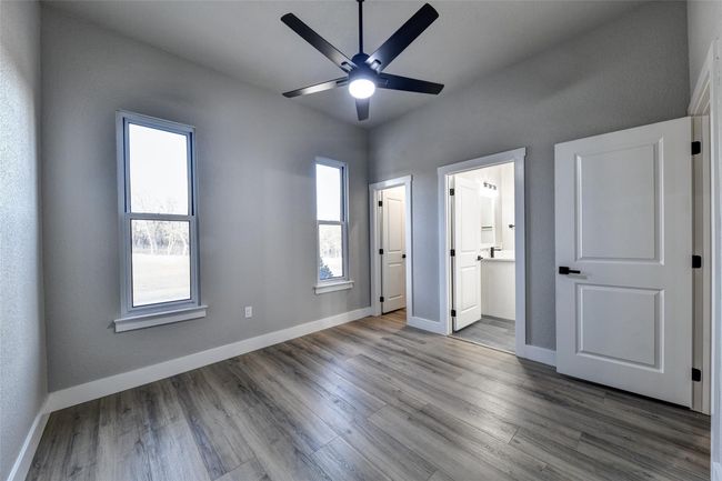 Unfurnished bedroom featuring ceiling fan, wood-type flooring, and ensuite bath | Image 26