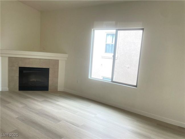 Unfurnished living room with a fireplace and light wood-type flooring | Image 10