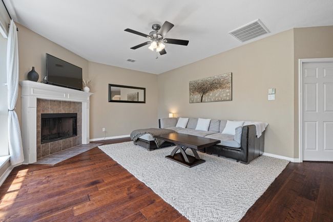 A corner fireplace adds warmth and definition to this spacious living room | Image 11