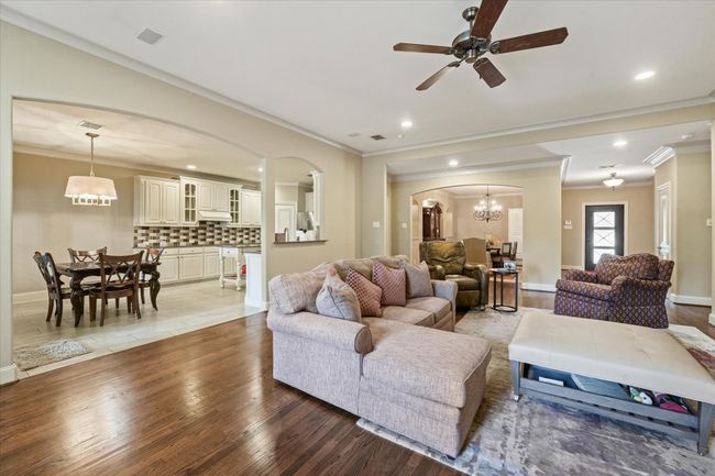 Living room with arched walkways, crown molding, light wood-style floors, recessed lighting, and baseboards | Image 12