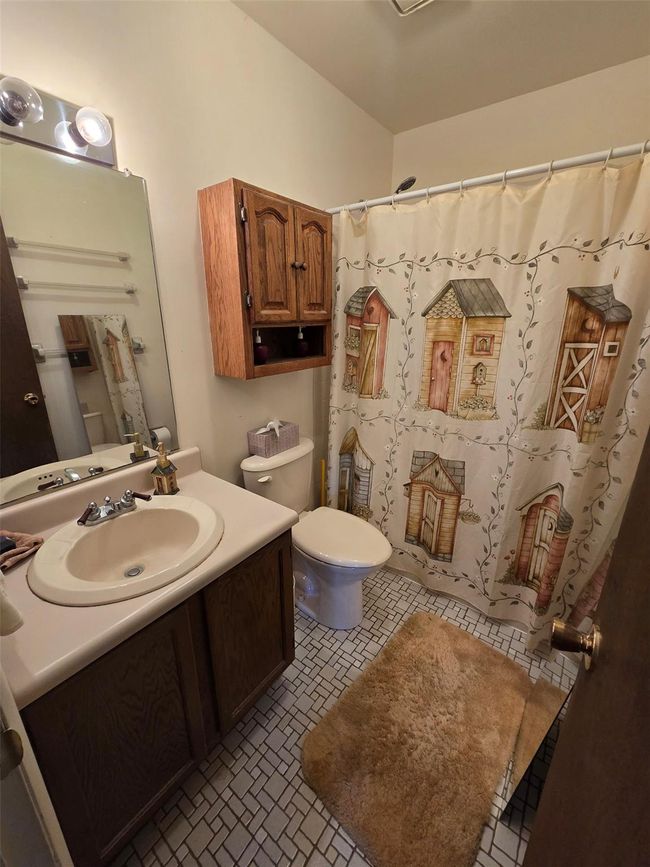 Full bathroom featuring toilet, vanity, and a shower with shower curtain | Image 6