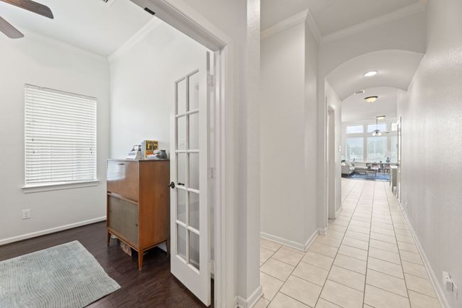 Corridor with crown molding, baseboards, arched walkways, and light tile patterned floors | Image 4