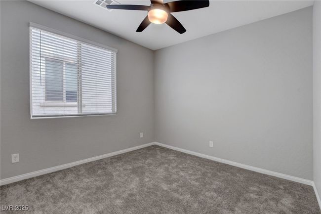 Carpeted empty room with a ceiling fan and baseboards | Image 11