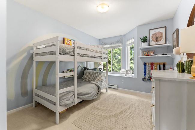 Bedroom featuring light colored carpet, baseboard heating, and baseboards | Image 24