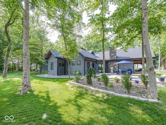 back of house featuring a yard, a chimney, a patio area, and a shingled roof | Image 41