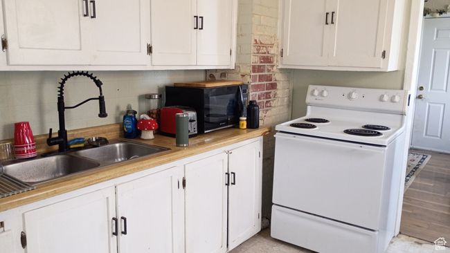 Kitchen featuring white electric range, white cabinetry and light countertops | Image 5