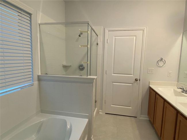 Bathroom with a stall shower, tile patterned flooring, a garden tub, and double vanity | Image 7