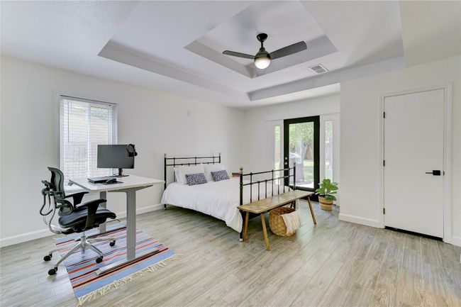 Bedroom featuring light wood-type flooring, visible vents, a tray ceiling, and baseboards | Image 10