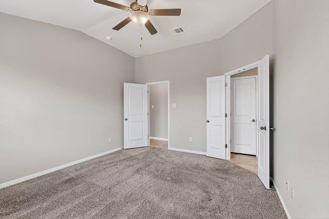Unfurnished bedroom featuring light carpet, high vaulted ceiling, and ceiling fan | Image 20