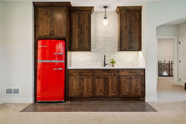 Wet bar with stone backsplash and knotty pine cabinetry | Image 44