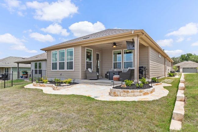 Rear view of property featuring a ceiling fan, a lawn, and fence | Image 32
