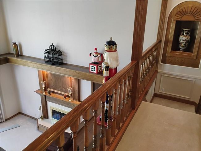 Staircase featuring a glass covered fireplace and carpet flooring | Image 64