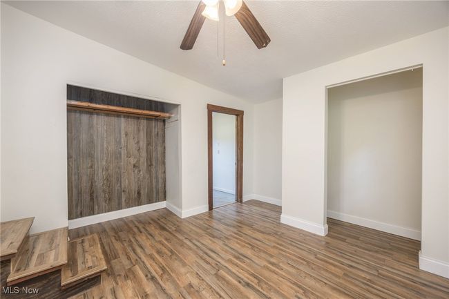 Unfurnished bedroom featuring wood finished floors, a closet, baseboards, and lofted ceiling | Image 13