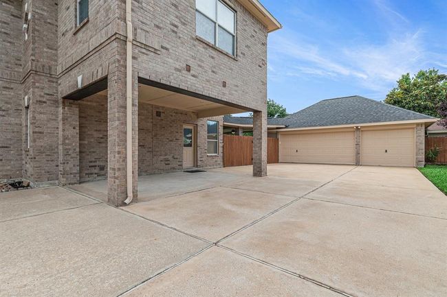 On those rainy days during a grocery haul, you might benefit from stopping under the porte-cochere and accessing the kitchen from the side door! This auto-court makes a great outdoor play space too! Add a basketball goal and you are golden! | Image 40