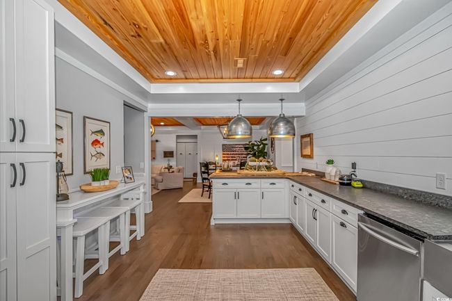 Kitchen featuring wooden ceiling, dishwasher, a peninsula, white cabinetry, and dark wood-style flooring | Image 9