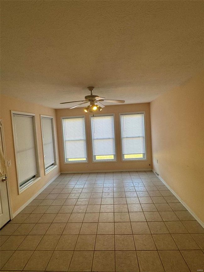 Unfurnished room featuring plenty of natural light, light tile patterned floors, and ceiling fan | Image 15