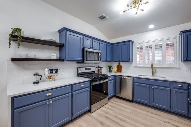 Kitchen featuring a sink, visible vents, appliances with stainless steel finishes, and blue cabinets | Image 10
