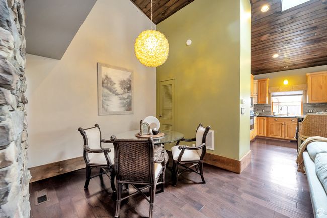 Dining space featuring a chandelier, high vaulted ceiling, dark wood finished floors, and wooden ceiling | Image 10