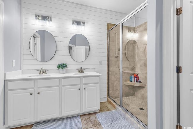 w/ dual vanity sinks, tiled walk-in-shower and ship lap accent wall. | Image 18