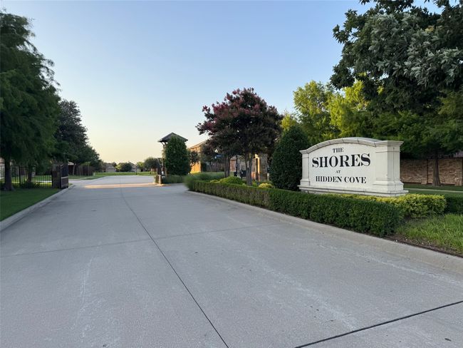 View of concrete road with curbs and a gated entry | Image 4