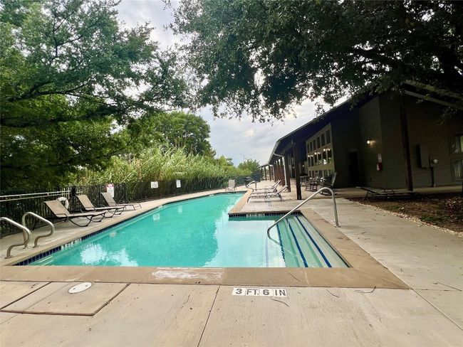 Community pool with a patio area. | Image 39