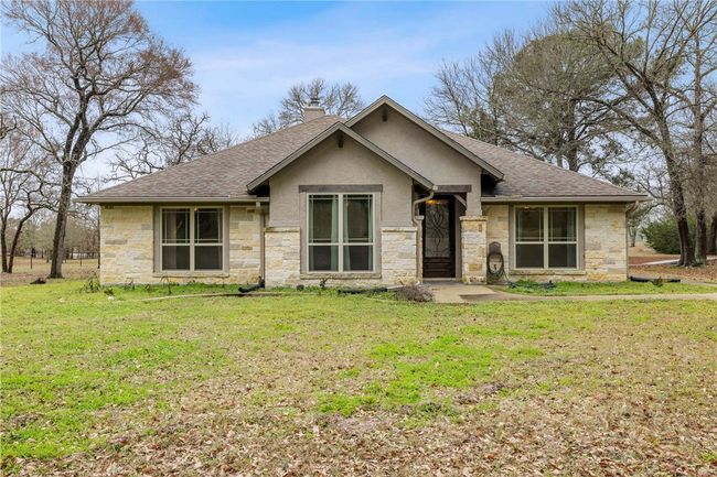 View of front facade with stucco siding, roof with shingles, a chimney, and a front yard | Image 29