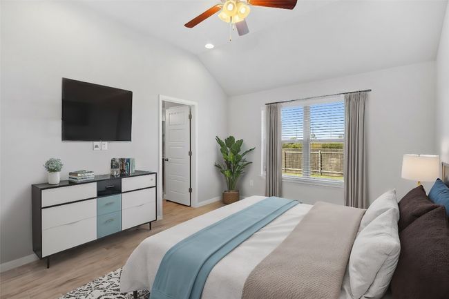 Virtually staged primary bedroom with ceiling fan and access to the primary bathroom and walk-in closet | Image 16