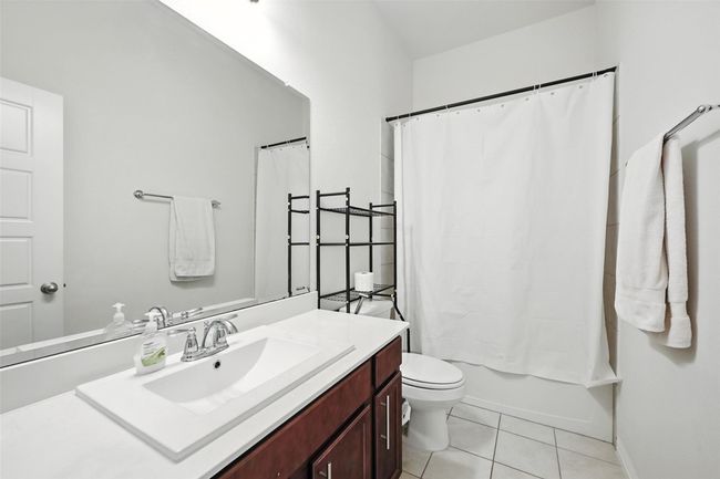 Full bathroom with vanity, tile patterned floors, and shower / bathtub combination with curtain | Image 22