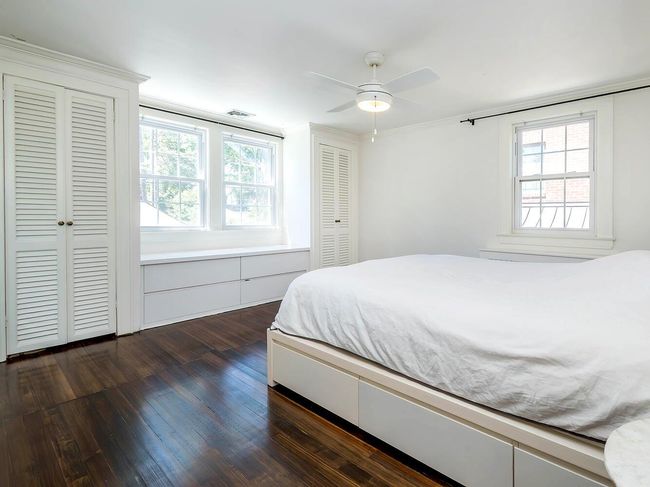 Primary Bedroom with hardwoodwood floors, multiple windows, and a ceiling fan | Image 15