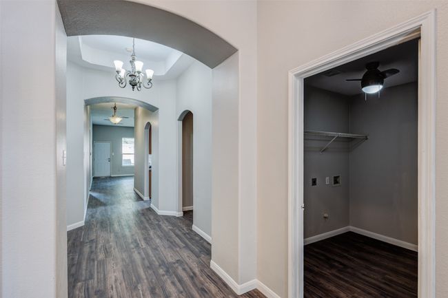 Kitchen featuring black appliances, a peninsula, arched walkways, light brown cabinets, and a ceiling fan | Image 11