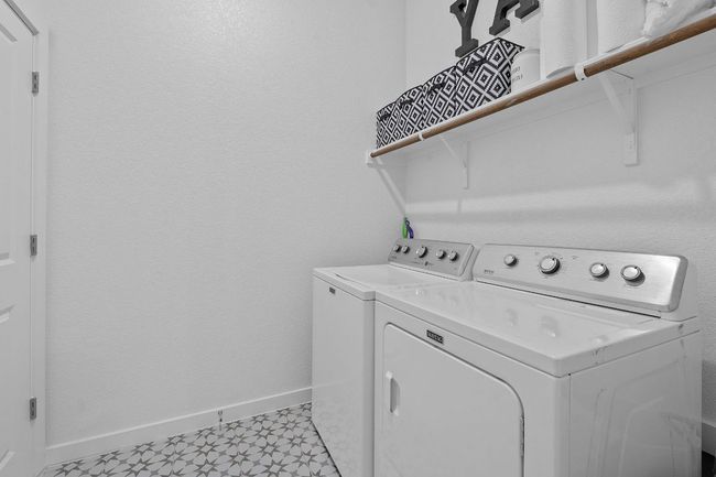 Laundry area featuring light floors, washing machine and dryer, baseboards, and laundry area | Image 24