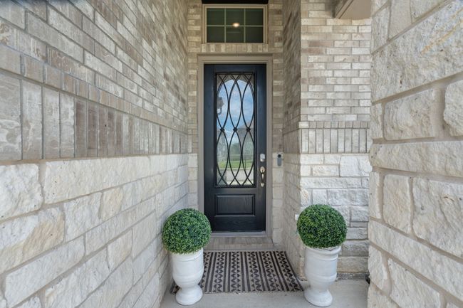 View of exterior entry with stone siding and brick siding | Image 4