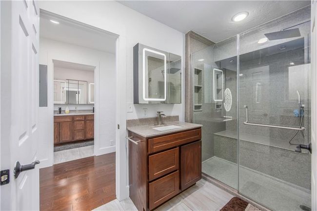 Full bath with a sink, wood finished floors, two vanities, and a stall shower | Image 43