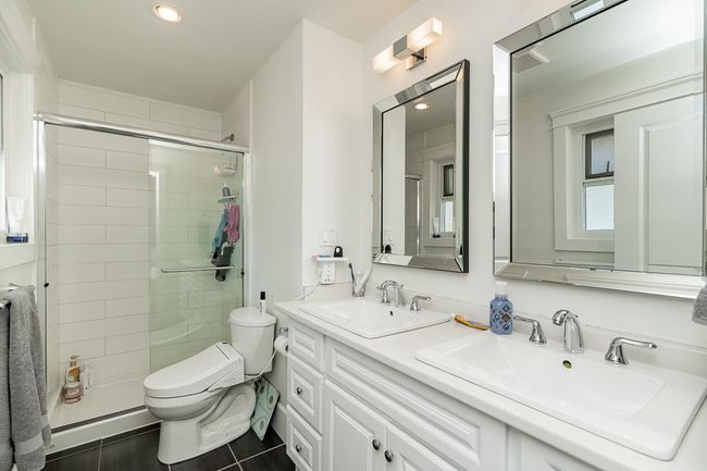 Bathroom featuring toilet, tile patterned flooring, a sink, and a shower stall | Image 15