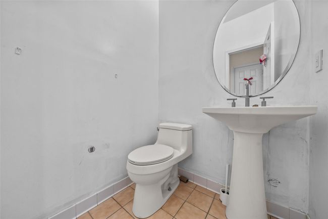 Half bath with toilet, tile patterned floors, and baseboards | Image 17