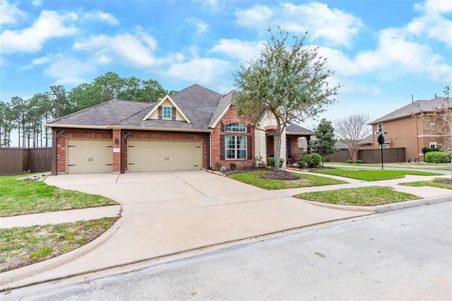 Three car attached garage with wide driveway for additional parking. | Image 7