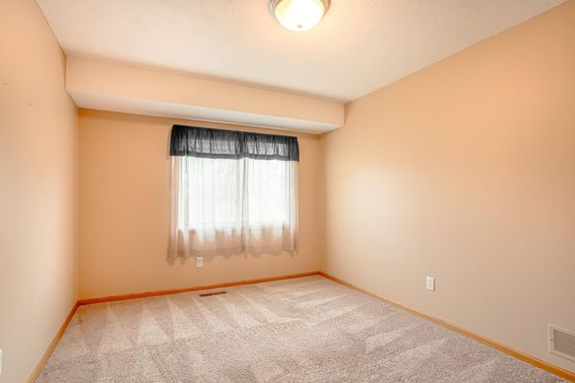 Inviting second bedroom offers natural light, neutral walls, and a calm atmosphere—great for guests or office use. | Image 20