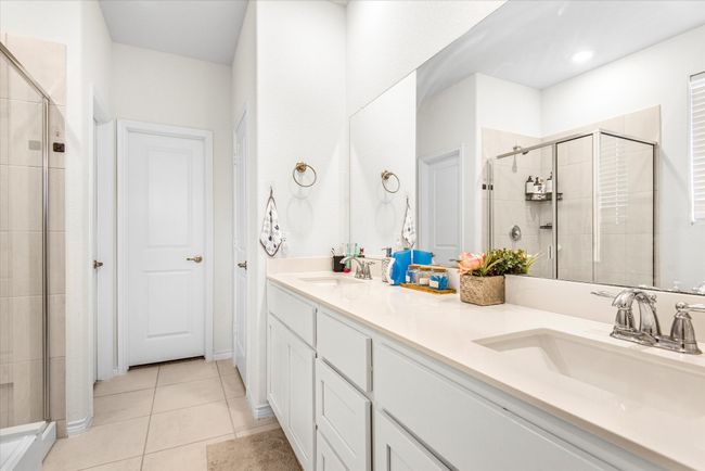 Bathroom with tile patterned flooring, a sink, a shower stall, and double vanity | Image 16