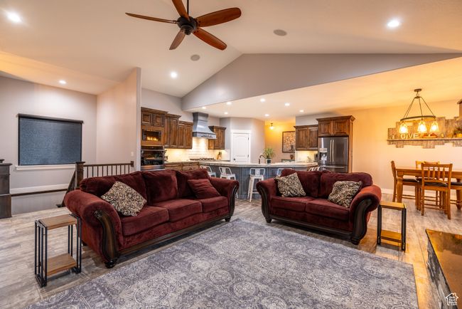 Living area with ceiling fan, a chandelier, vaulted ceiling, recessed lighting, and light wood-style flooring | Image 12