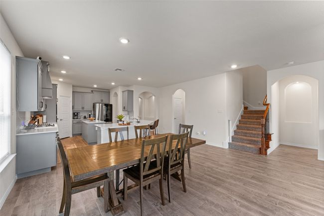 Dining area with arched walkways, recessed lighting, light wood-style flooring, and stairs | Image 8