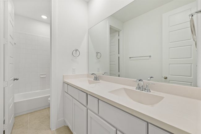 Bathroom with toilet, tile patterned floors, a sink, and double vanity | Image 13