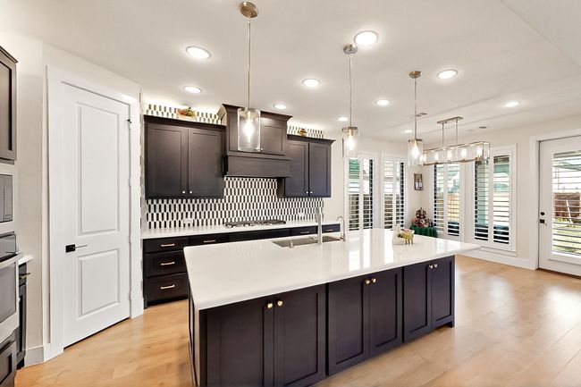 Kitchen with gas cooktop, custom exhaust hood, plenty of natural light, a sink, and recessed lighting | Image 12